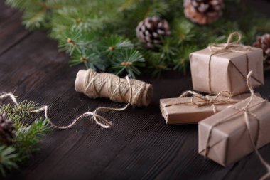 Ahşap arka plan ağaç, çam kozalakları ve karton kutular ile Noel kompozisyonu