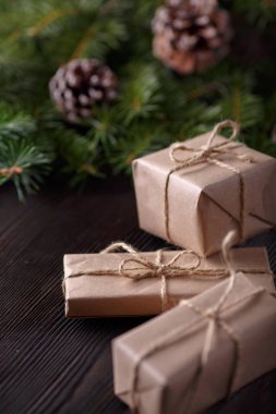 Ahşap arka plan ağaç, çam kozalakları ve karton kutular ile Noel kompozisyonu