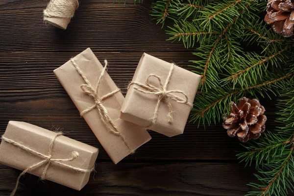 Χριστουγεννιάτικη σύνθεση σε ξύλινα φόντο με δέντρου, κουκουνάρια και κουτιά από χαρτόνι — Φωτογραφία Αρχείου