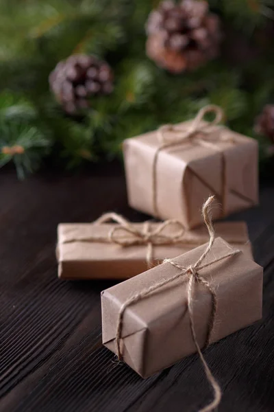 Composición navideña sobre fondo de madera con árbol, conos de pino y cajas de cartón —  Fotos de Stock