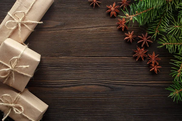 Χριστουγεννιάτικη σύνθεση σε ξύλινα φόντο με δέντρου, κουκουνάρια, αστεροειδή γλυκάνισο και κουτιά από χαρτόνι — Φωτογραφία Αρχείου