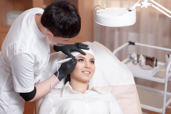 Cosmetólogo aplicando maquillaje permanente en las cejas tatuaje de cejas —  Fotos de Stock