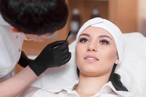 Hermosa mujer joven obtiene procedimiento de corrección de cejas — Foto de Stock