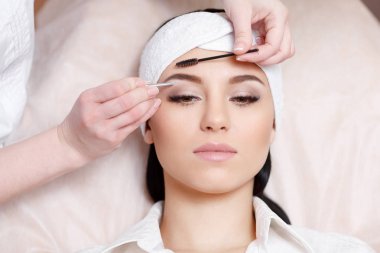 Beautiful young woman gets eyebrow correction procedure