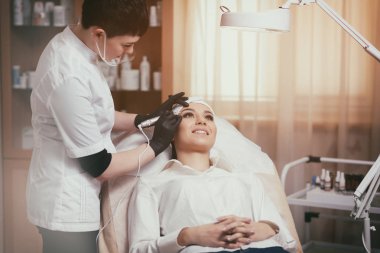 Kozmetik uzmanı kaşlarına kalıcı makyaj uyguluyor.