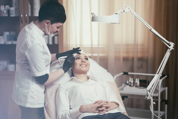 Cosmetólogo aplicando maquillaje permanente en las cejas tatuaje de cejas —  Fotos de Stock