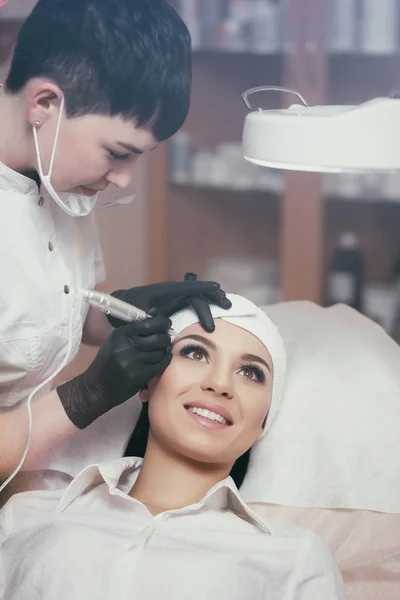 Cosmetólogo aplicando maquillaje permanente en las cejas tatuaje de cejas —  Fotos de Stock