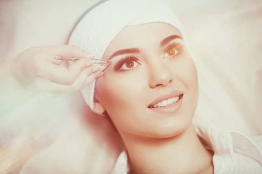 Genç kadın güzellik salon kaşlarını tweezing