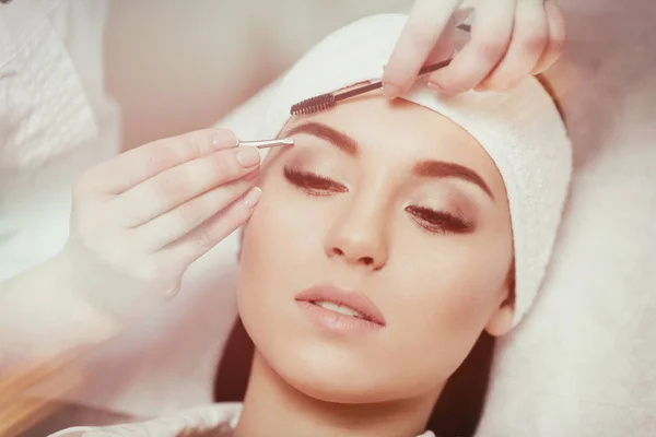 Beautiful young woman gets eyebrow correction procedure — Stock Photo, Image