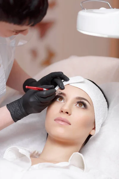 Asistente de maquillaje permanente hace procedimiento de corrección de cejas —  Fotos de Stock