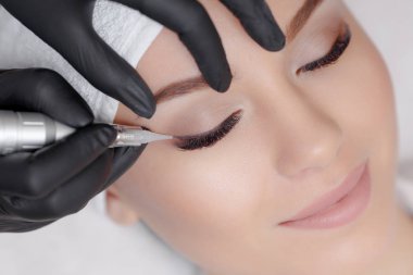 Kozmetik uzmanı kalıcı makyaj yapıyor