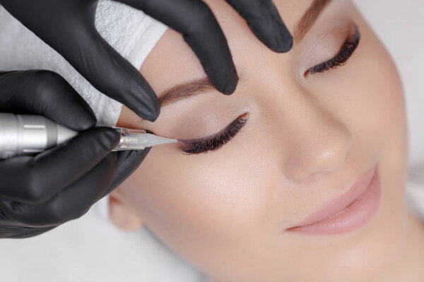 Cosmetologist making permanent makeup