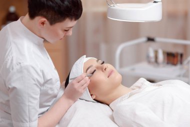 Stilist uzatma kirpikleri yapma beyaz üniformalı