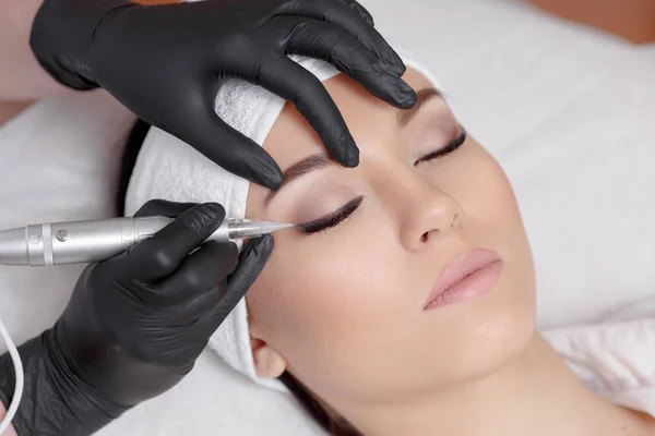 Cosmetólogo haciendo maquillaje permanente en el salón de belleza . — Foto de Stock