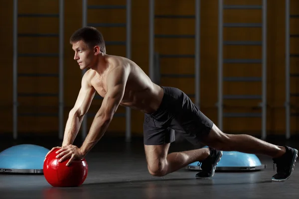 Homme poussant sur les mains de plancher médecine ballon . — Photo