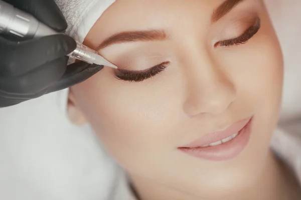 Cosmetólogo haciendo maquillaje permanente en el salón de belleza —  Fotos de Stock