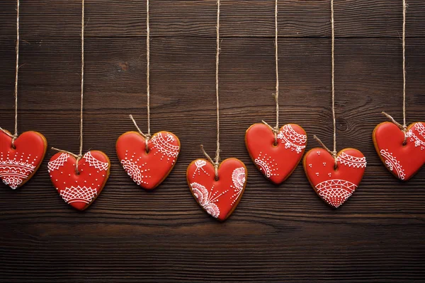 Line of red gingerbreads hearts on ribbon. — Stock Photo, Image