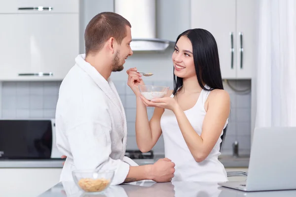 Frau füttert ihren Mann mit Haferflocken. — Stockfoto