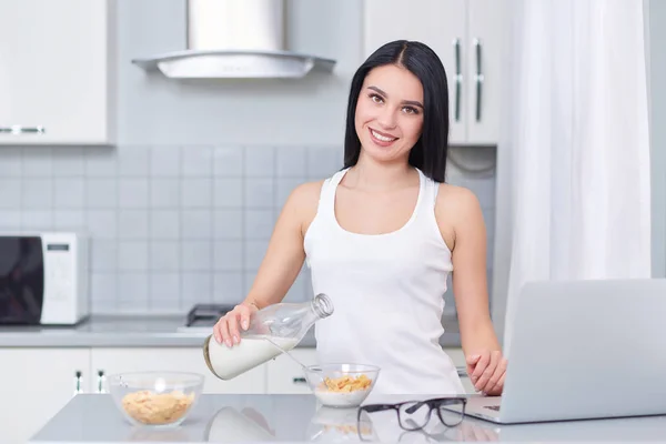 Frau lächelt und hält Löffel mit Eichenflocken. — Stockfoto