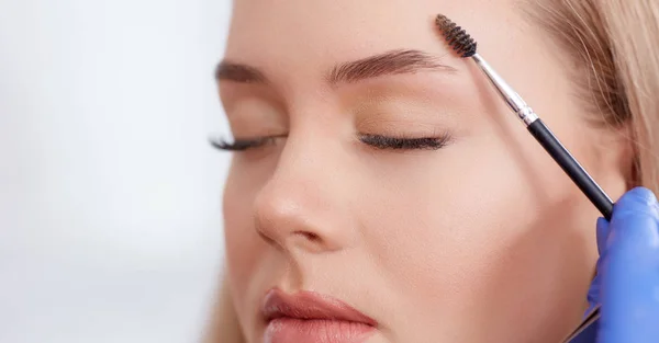 Combing eyebrows and preparing for makeup. — Stock Photo, Image