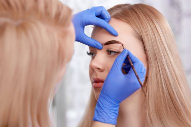 Kaşları sarışın kadın için kalıcı makyaj.