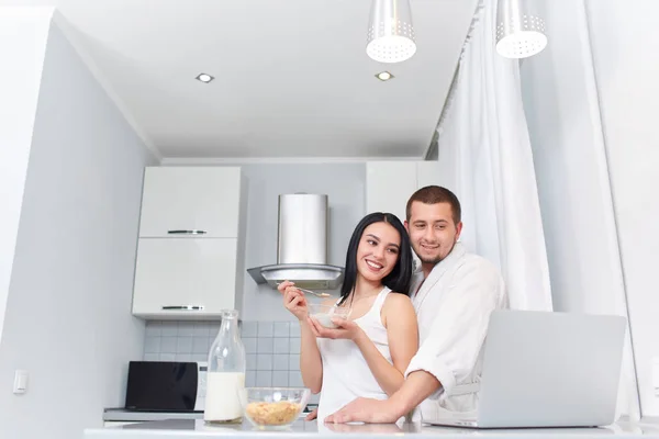 Couple having breakfast at kitchen and watching news. — Stock Photo, Image