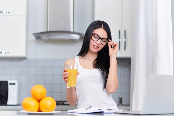 Successfully woman in eyeglasses reading and drinking juice. — Stock Photo, Image