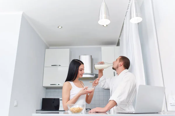 Wife eating porridge and husband drinking milk. — Stock Photo, Image