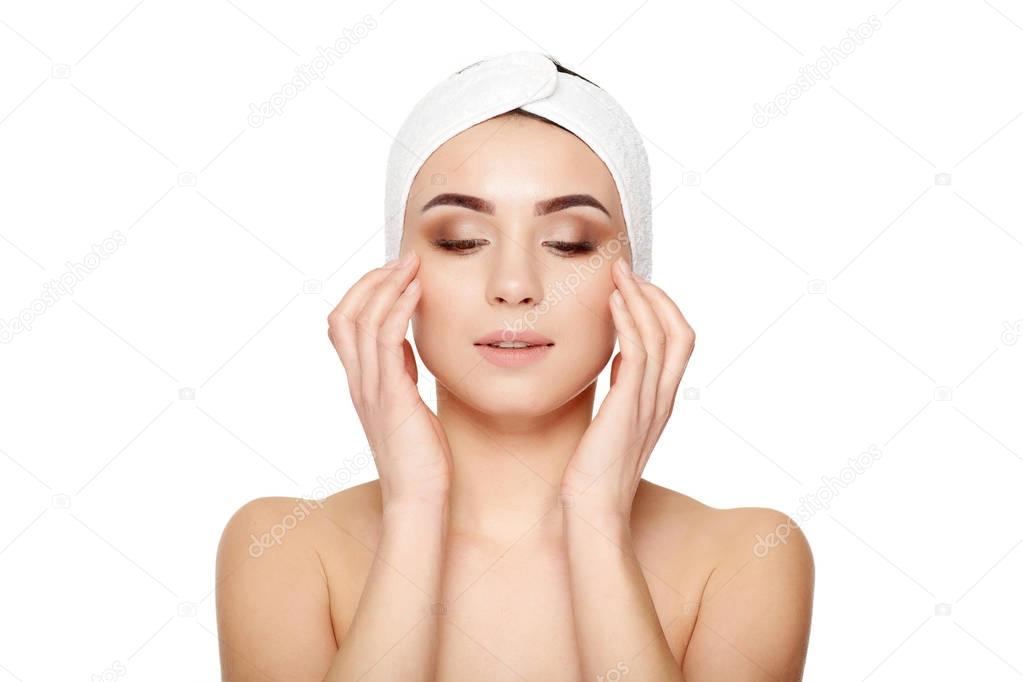 Beautiful young woman touching her face on a white background