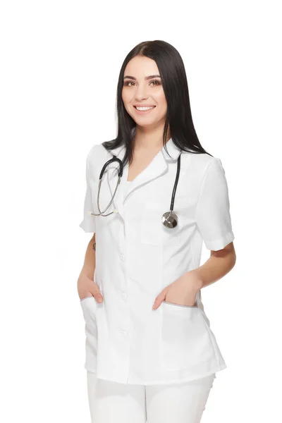 Красивая медсестра со стетоскопом вокруг шеи, держащая руки в карманах . — стоковое фото