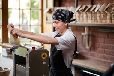 Kadın aşçılar hamur makarna yapmak için makine üzerinde
