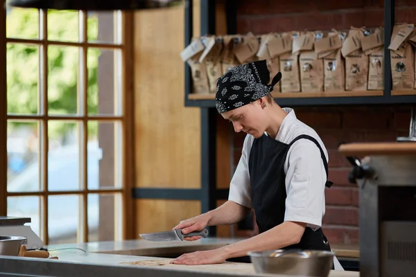 Woman slicing noodles in cafe — Stock Photo, Image