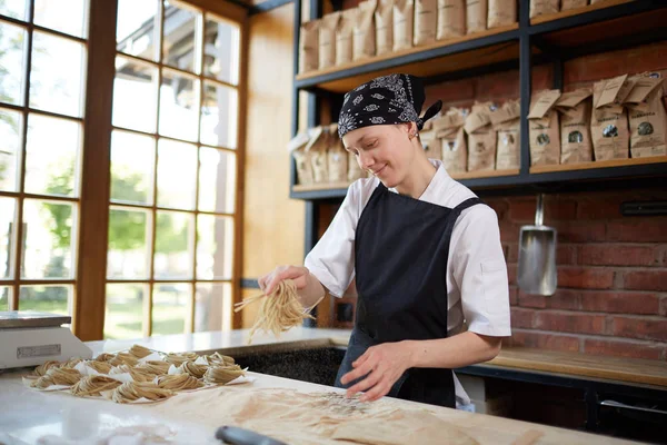 Donna che cucina tagliatelle in caffè — Foto Stock