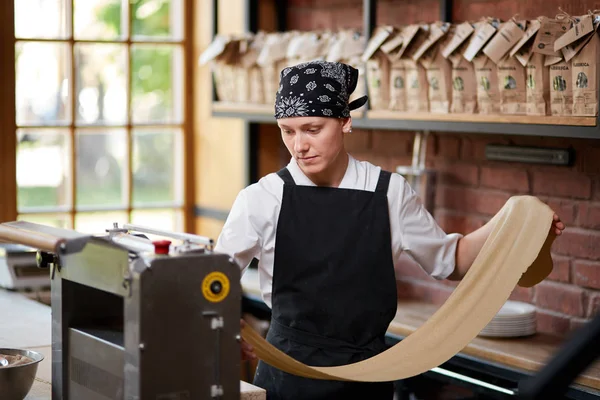 Kadın aşçılar hamur makarna yapmak için makine üzerinde