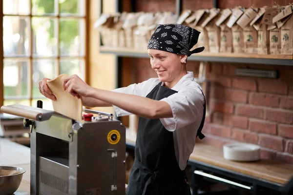 Donna cucina pasta sulla macchina per fare la pasta — Foto Stock