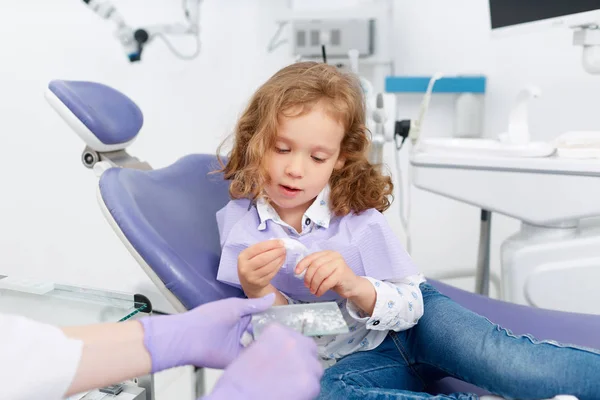 Kleines Mädchen spielt mit Zahnwerkzeugen — Stockfoto