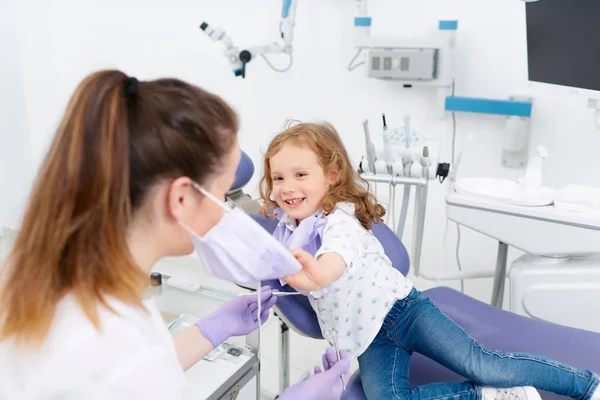 Chica quitando máscara forma dentista —  Fotos de Stock