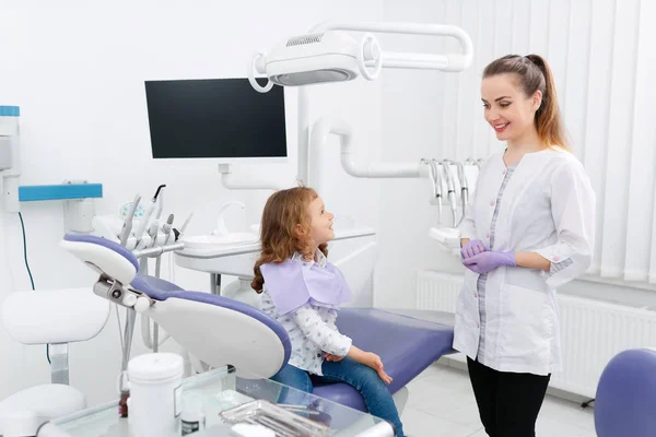Стоматолог і маленька дівчинка в кабінеті — стокове фото