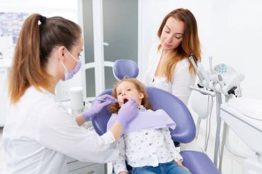 Küçük kız inceleyerek diş hekimleri