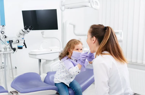 Petite fille regardant dans la bouche du dentiste — Photo