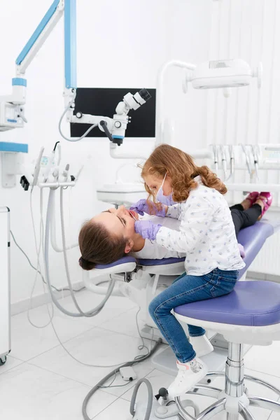 Liten flicka undersökande tandläkare i skåp — Stockfoto