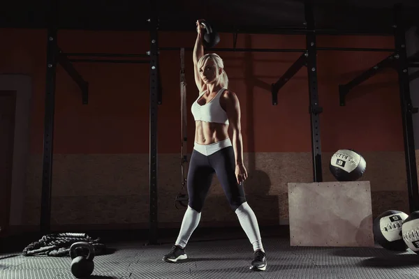 Muscular joven fitness mujer levantando un peso en el gimnasio — Foto de Stock