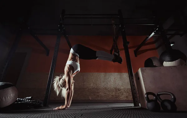 Fitness žena cvičení na Trx v tělocvičně — Stock fotografie