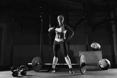 Genç fitness kız spor salonunda duruyor