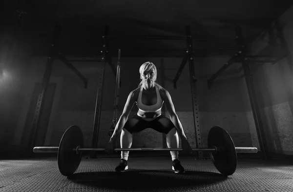 Gespierde jonge fitness vrouw in de sportschool — Stockfoto