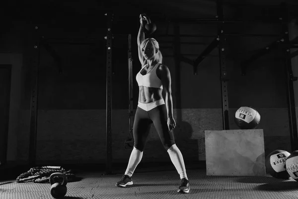 Muscular joven fitness mujer levantando un peso en el gimnasio —  Fotos de Stock