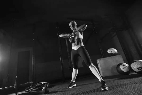 Wanita kebugaran muda berotot mengangkat beban di gym — Stok Foto