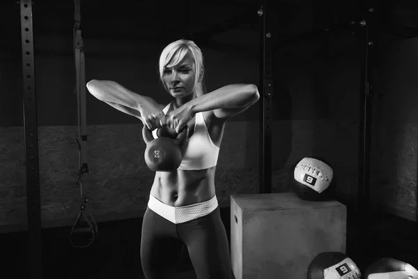 Muscular joven fitness mujer levantando un peso en el gimnasio — Foto de Stock