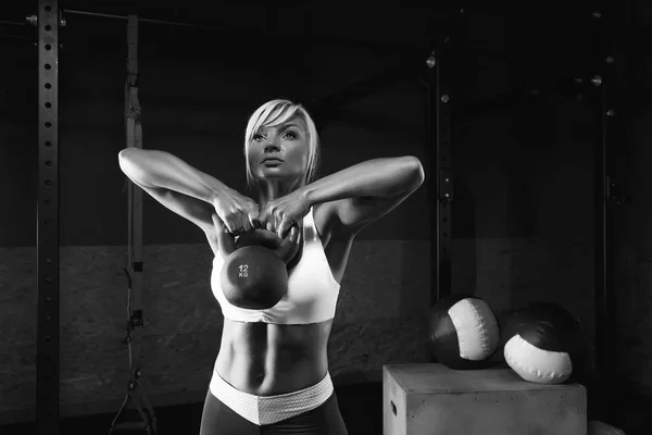 Muscular jovem mulher fitness levantando um peso no ginásio — Fotografia de Stock