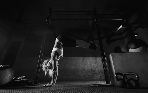 Vrouw fitnesstraining op de Trx in de sportschool — Stockfoto